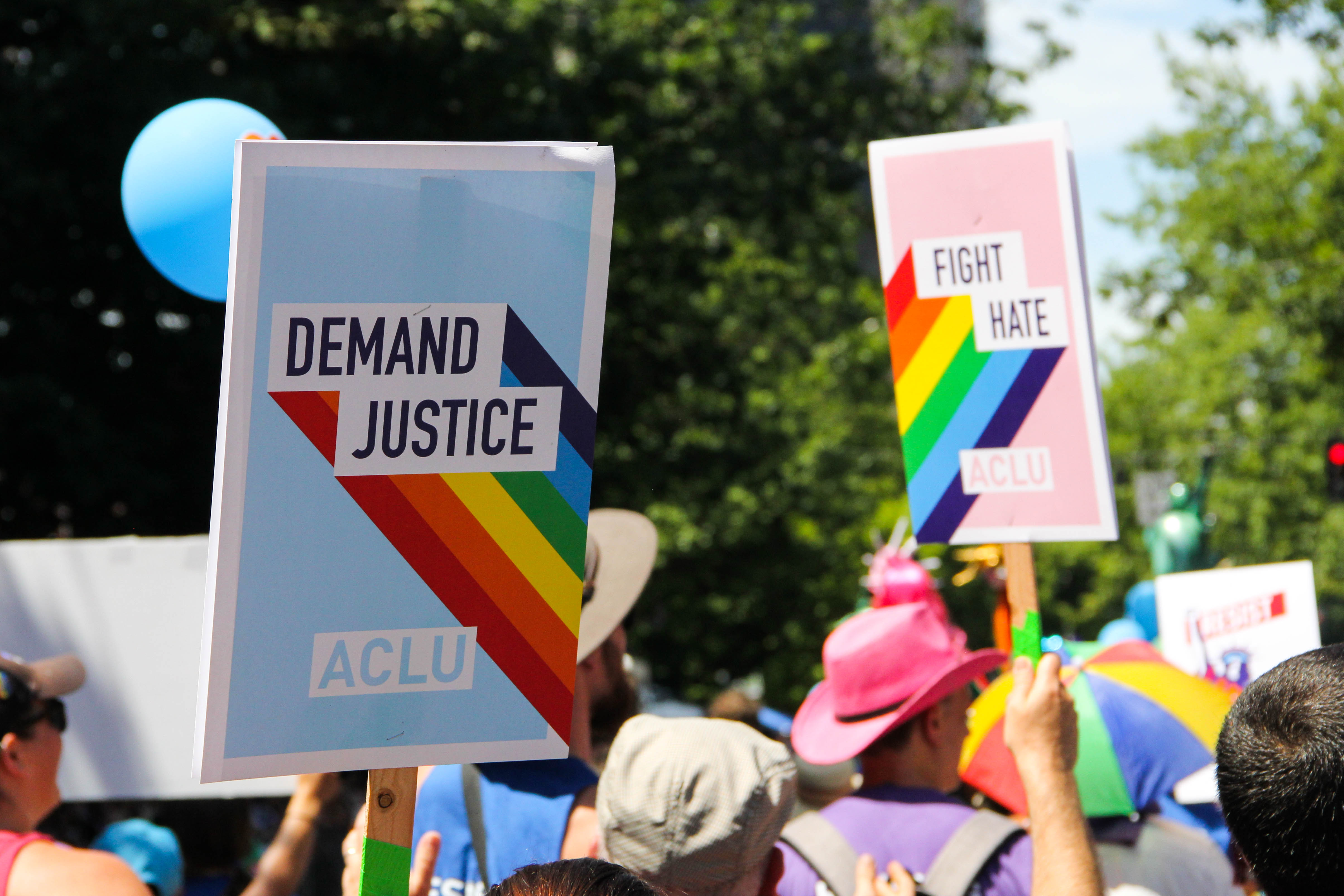 People marching for Pride. One visible signs reads "Demand Justice"