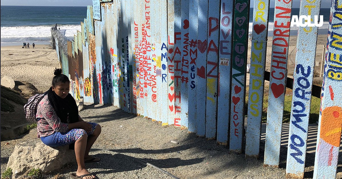 Woman seated near fence