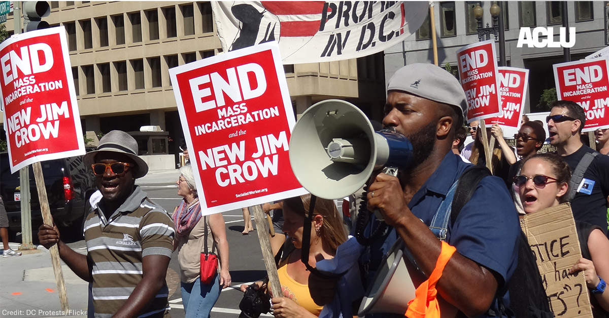 Demonstrators carry signs advocating an end to mass incarceration